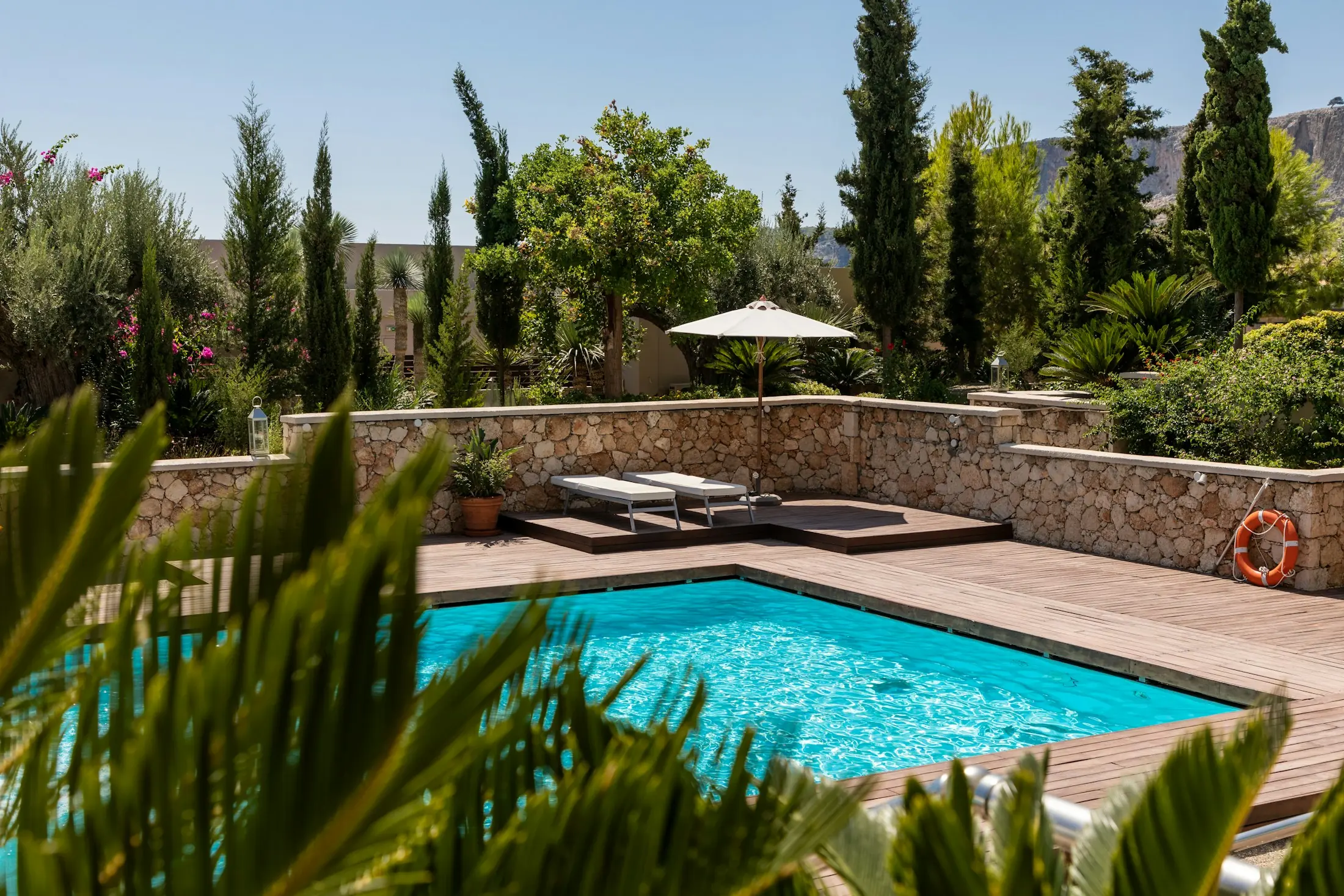 Les reflets d’une piscine et sa terrasse en bois